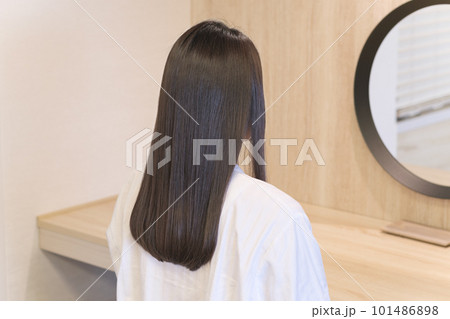 鏡を見る女性の艶のあるロングヘア 101486898