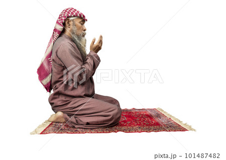 Muslim man with a beard wearing keffiyeh with agal in praying position (salat) on the prayer rug Muslim man with a beard wearing keffiyeh with agal in praying position (salat) on the prayer rug 101487482