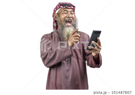 Muslim man with a beard wearing keffiyeh with agal using mobile phone 101487607