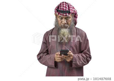 Muslim man with a beard wearing keffiyeh with agal using mobile phone 101487608
