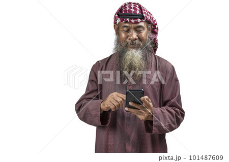 Muslim man with a beard wearing keffiyeh with agal using mobile phone 101487609