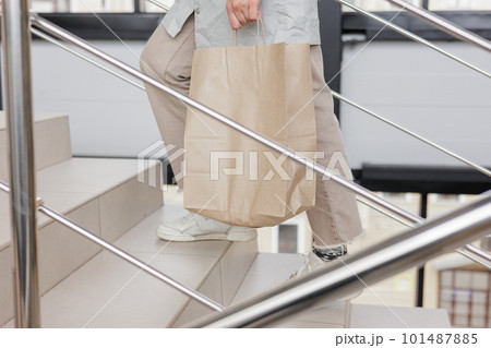 person carries food delivery in paper bag for an online buyer. delivery of orders from online store person carries food delivery in paper bag for an online buyer. delivery of orders from online store 101487885