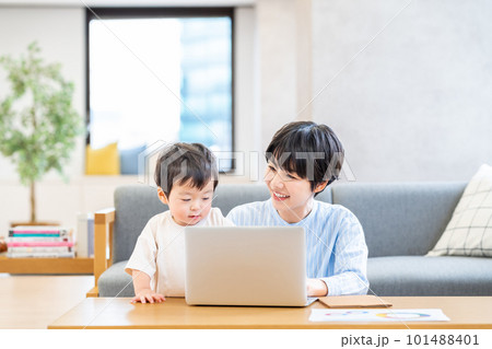 リビングでテレワークをする女性と幼児 リビングでテレワークをする女性と幼児 101488401