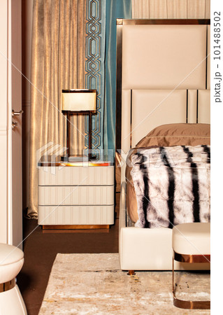 A fragment of the bedroom interior, part of the bed with a fur bedspread in pastel beige tones. A fragment of the bedroom interior, part of the bed with a fur bedspread in pastel beige tones. 101488502
