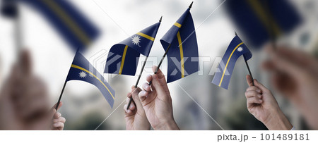 A group of people holding small flags of the Nauru in their hands A group of people holding small flags of the Nauru in their hands 101489181