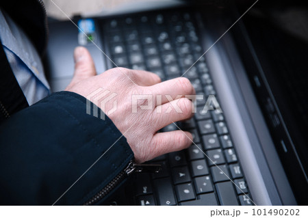 Men's hand typing on a laptop keyboard. Selective focus 101490202