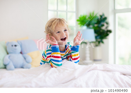Child playing in bed. Kids room. Baby boy at home. 101490490