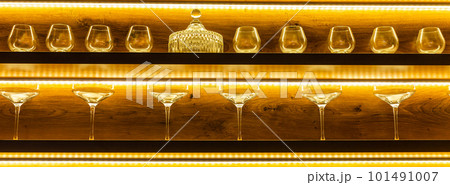 Glasses of wine. Glasses hanging above the bar in restaurant. Empty glasses for wine. Wine and martini glasses in shelf above bar rack in restaurant. night life Glasses of wine. Glasses hanging above the bar in restaurant. Empty glasses for wine. Wine and martini glasses in shelf above bar rack in restaurant. night life 101491007