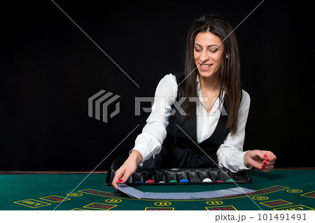 The beautiful girl, dealer, behind a table for poker 101491491