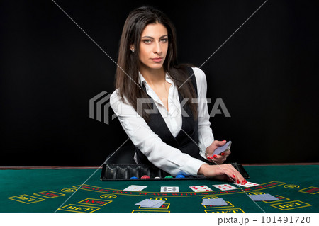 The beautiful girl, dealer, behind a table for poker The beautiful girl, dealer, behind a table for poker 101491720