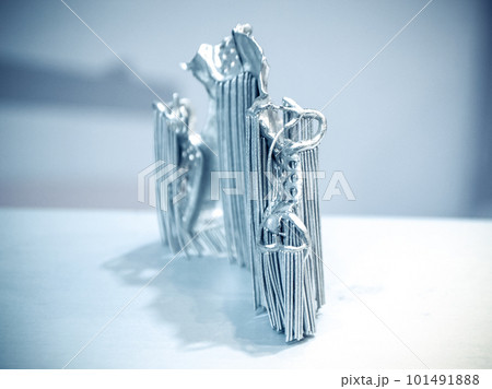 Object printed on metal 3d printer. Dental crowns printed in laser sintering machine. Modern 3D printer printing from metal powder. Concept progressive additive DMLS, SLM, SLS 3d printing technology. Object printed on metal 3d printer. Dental crowns printed in laser sintering machine. Modern 3D printer printing from metal powder. Concept progressive additive DMLS, SLM, SLS 3d printing technology. 101491888