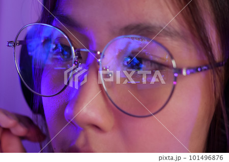 Female gamer wearing glasses for reducing eye strain blurred vision at home 101496876