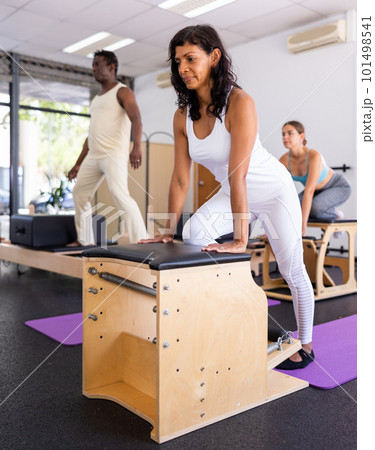 Hispanic woman is engaged in pilates training in gym 101498541