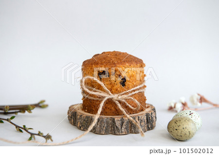 Easter baking. Quail eggs lie near the Easter cake with a ribbon on a wooden stand. Raisin Pie Easter baking. Quail eggs lie near the Easter cake with a ribbon on a wooden stand. Raisin Pie 101502012