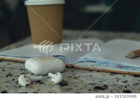 Take away coffee in craft recycling paper cup with paper notebook with wireless headphones. Mockup Coffee break. Audio healing, sound therapy wellness rituals, positive mental health habits listening Take away coffee in craft recycling paper cup with paper notebook with wireless headphones. Mockup Coffee break. Audio healing, sound therapy wellness rituals, positive mental health habits listening 101503990