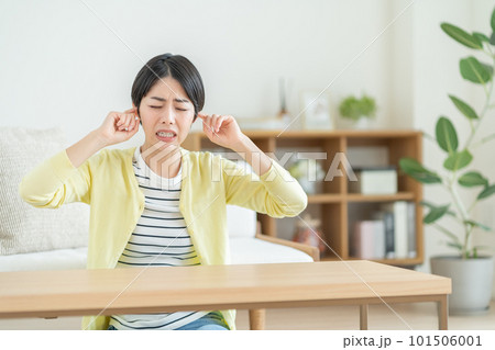 耳鳴りに悩む女性　騒音に悩む女性　不安を抱える女性　何かを考える女性 101506001