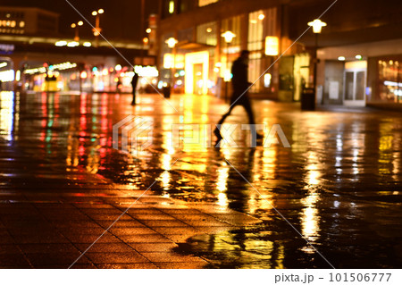 Man walks in the dark in the rain at the station forecourt in Essen, Germany Man walks in the dark in the rain at the station forecourt in Essen, Germany 101506777