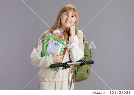 happy trendy school girl in beige tracksuit with backpack 101508031