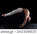 flexible circus artist keep balance on hands on a black background. concept of contortion and flexibility  101509815