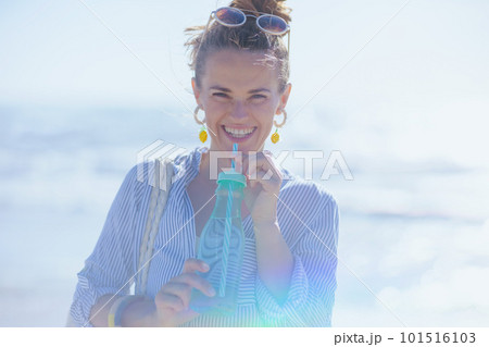 Portrait of smiling elegant woman at beach 101516103