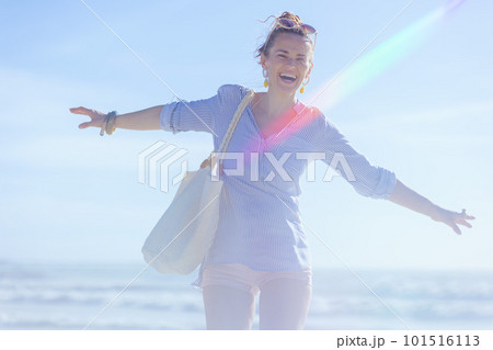 smiling stylish 40 years old woman rejoicing at beach 101516113