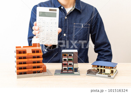 住宅模型の前で電卓を持つ男性 101516324