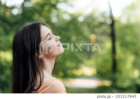 Ways To Unplug From Technology and Be Present. Unplugging from Technology and Living a More Mindful Life. Outdoor portrait of young woman enjoying nature 101517645