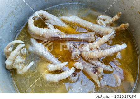 boiled chicken paws with broth in aluminium casserole for natural dog food, closeup with selective focus 101518084