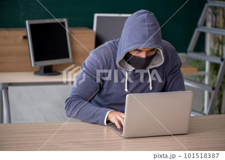 Young male hacker sitting in the classroom 101518387