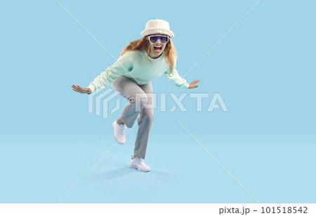 Cheerful crazy young woman laughs and dances cheerfully on light blue background. Cheerful crazy young woman laughs and dances cheerfully on light blue background. 101518542