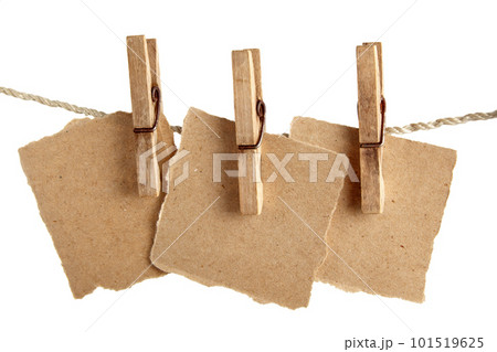Craft note paper pinned with a vintage clothespin on a rope on a white background Craft note paper pinned with a vintage clothespin on a rope on a white background 101519625
