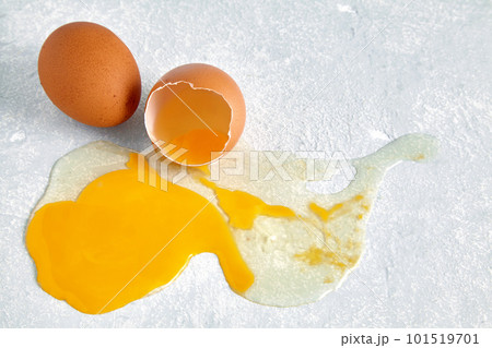 Broken and leaking chicken egg that fell on the concrete floor Broken and leaking chicken egg that fell on the concrete floor 101519701