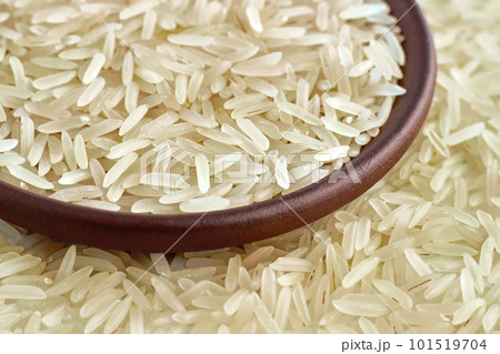 Healthy basmati rice in a clay ceramic bowl close-up against the background of scattered grains of rice Healthy basmati rice in a clay ceramic bowl close-up against the background of scattered grains of rice 101519704