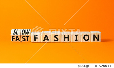 Fast or slow fashion symbol. Concept words Fast fashion and Slow fashion on wooden cubes. Beautiful orange table orange background. Business fast or slow fashion concept. Copy space. 101520044