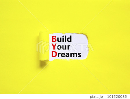 BYD build your dreams symbol. Concept words BYD build your dreams on white paper on a beautiful yellow background. Business and BYD build your dreams concept. Copy space. 101520086
