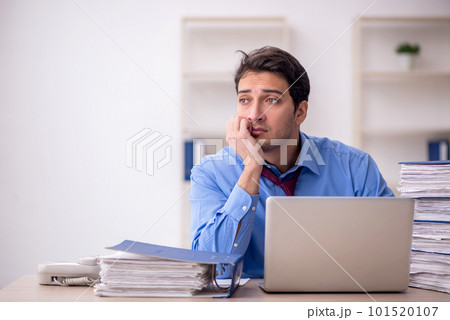 Young male employee and too much work in the office Young male employee and too much work in the office 101520107