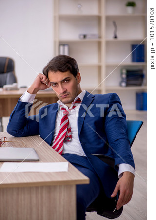 Young male employee and too much work in the office 101520108