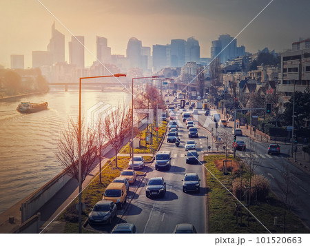 Busy traffic on highway and city streets creating high pollution and smog. Urban sunset view across Seine river to La Defense metropolitan district, Paris, France Busy traffic on highway and city streets creating high pollution and smog. Urban sunset view across Seine river to La Defense metropolitan district, Paris, France 101520663