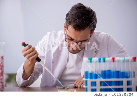 Young male chemist in front of white board 101520804