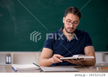 Young male teacher sitting in the classroom Young male teacher sitting in the classroom 101521129