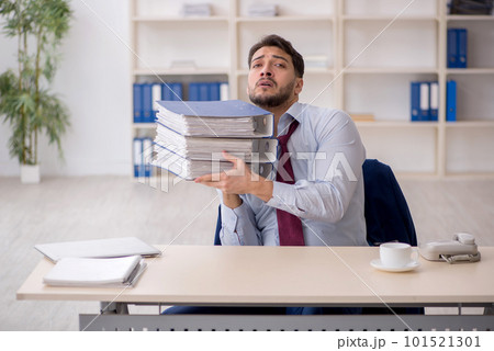 Young male employee sitting at workplace 101521301