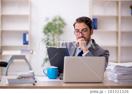 Young male employee and too much work in the office Young male employee and too much work in the office 101521326