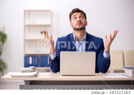 Young male employee sitting at workplace 101521363