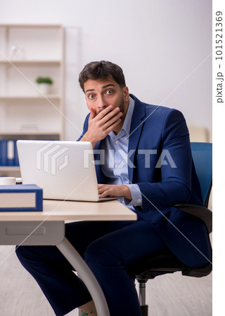 Young male employee sitting at workplace Young male employee sitting at workplace 101521369