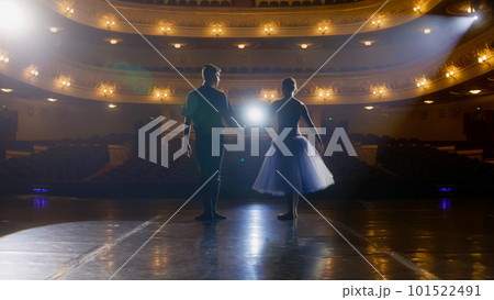 Ballet dancers bow down in front of rows of seats 101522491