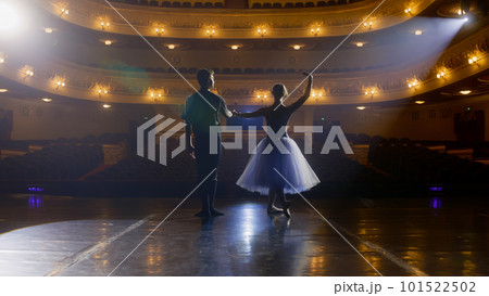 Ballet dancers bow down in front of rows of seats 101522502