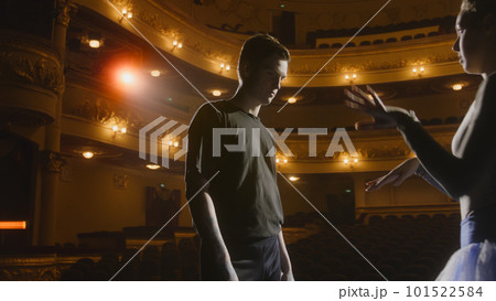 Ballerina with partner stands on theater stage Ballerina with partner stands on theater stage 101522584