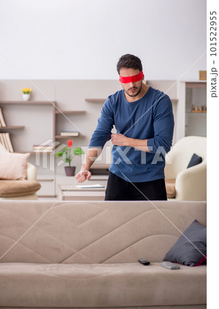 Blindfolded young man at home Blindfolded young man at home 101522955