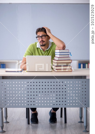 Young male student preparing for exams in the classroom 101523029