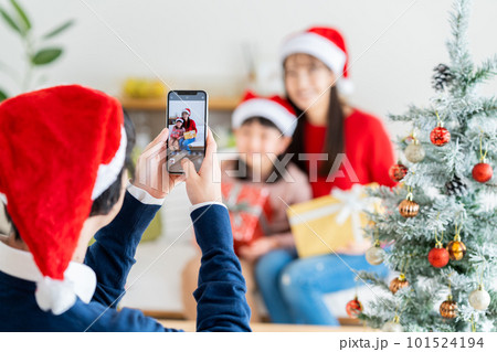 クリスマスの写真を撮る若い家族 101524194